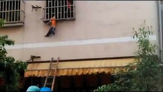 Home alone boy hangs off building with head caught between bars