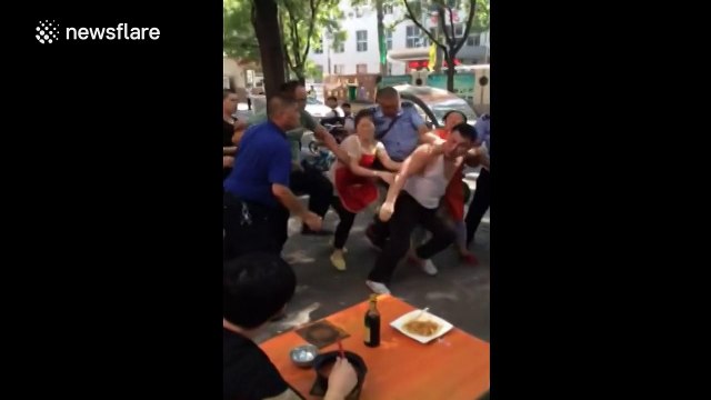 Man calmly finishes noodles as street brawl breaks out around him