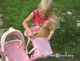 This little girls thinks his cat is a doll.. Poor kitten