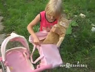 This little girls thinks his cat is a doll.. Poor kitten