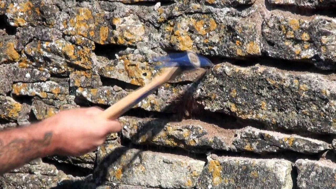 Raking or chopping out joints in stone walls for repointing