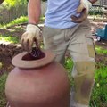 Men help a Duck stuck in a pottery with pine cones