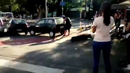 Il déplace à mains nues une voiture garée sur une piste cyclable