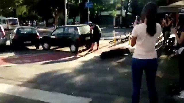 Il déplace à mains nues une voiture garée sur une piste cyclable