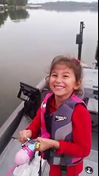 Une petite fille attrape un poisson avec sa canne à pêche Barbie