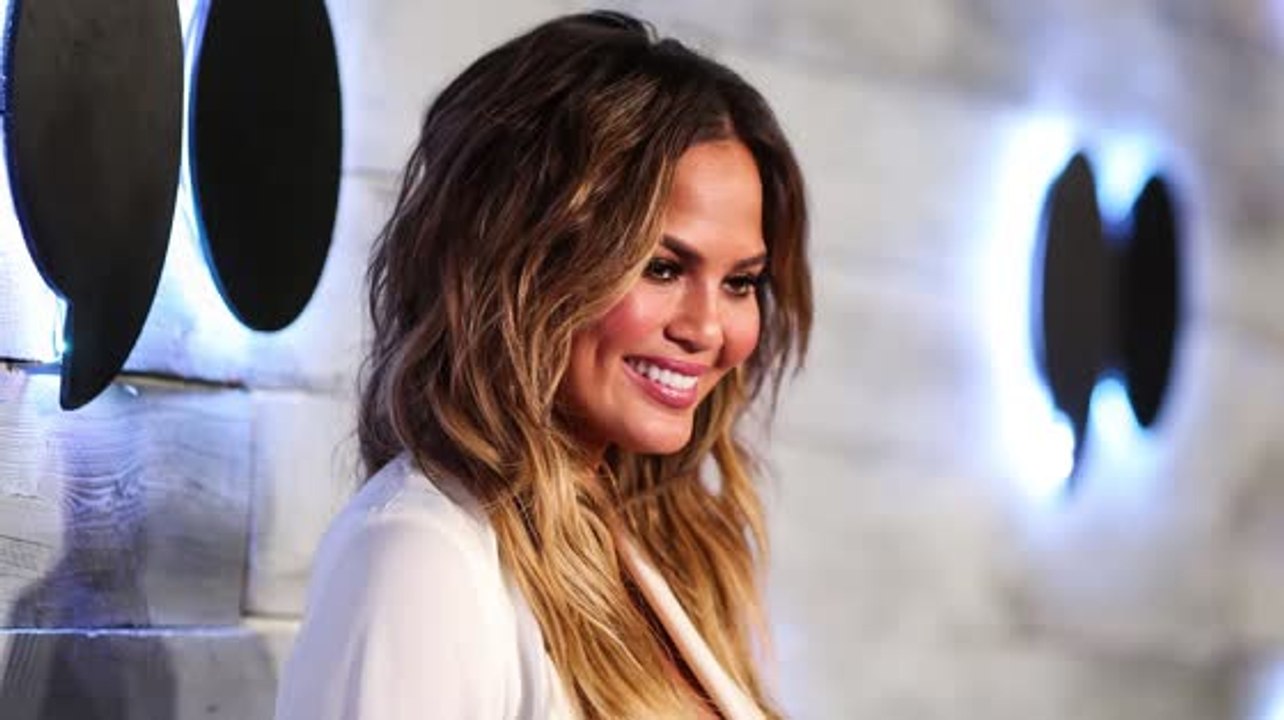 Chrissy Teigen coupe le souffle en blanc après avoir révélé avoir des problèmes de fertilité
