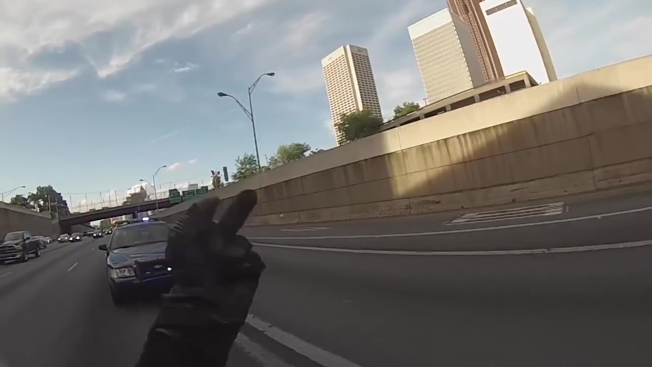 Un motard fait un wheeling devant une voiture de police et sème les policiers