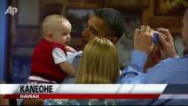 Un bébé met ses doigts dans la bouche de Barack Obama