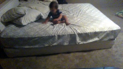 Smart baby throws down pillows to get off a higher bed