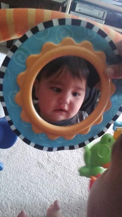 Baby cracks up after discovering his reflection