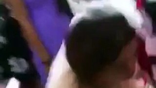 Guests tease bride by kissing her in neck at wedding party