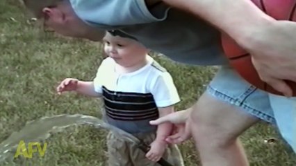 Adorable baby boy attempts to drink water from a hose
