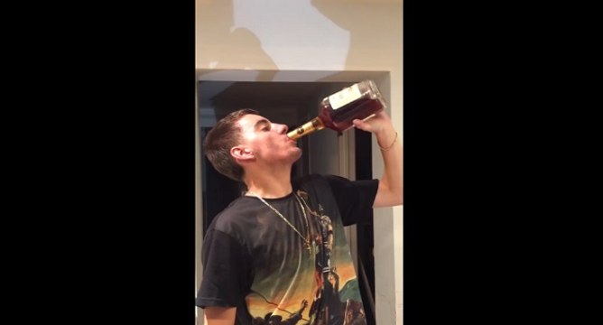 Un jeune fou boit une bouteille de cognac cul sec