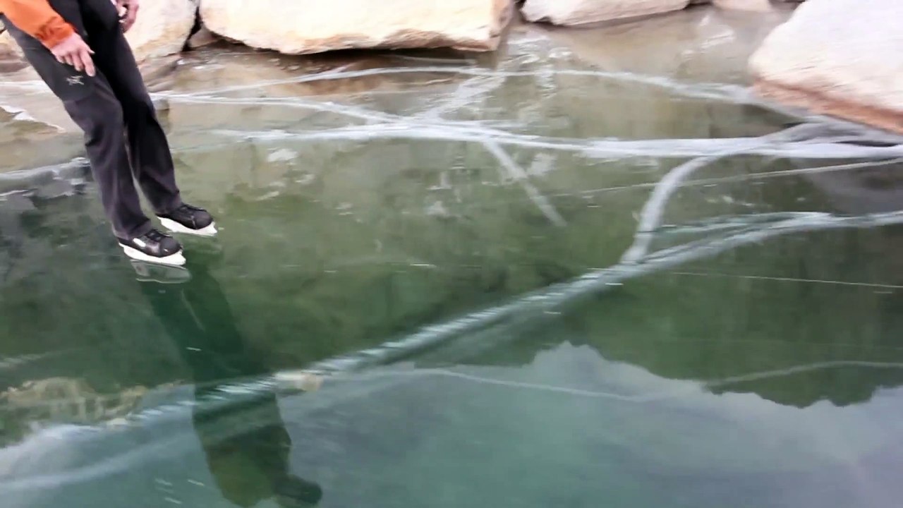 Faire du patin à glace sur une rivière gelée complètement transparente