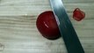 Un couteau à sashimi très très aiguisé coupe une tomate en fines lamelles