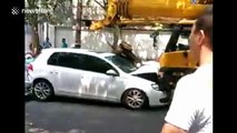 Crane crushes six cars after driver faints