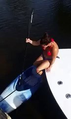 A girl climbs Into a kayak