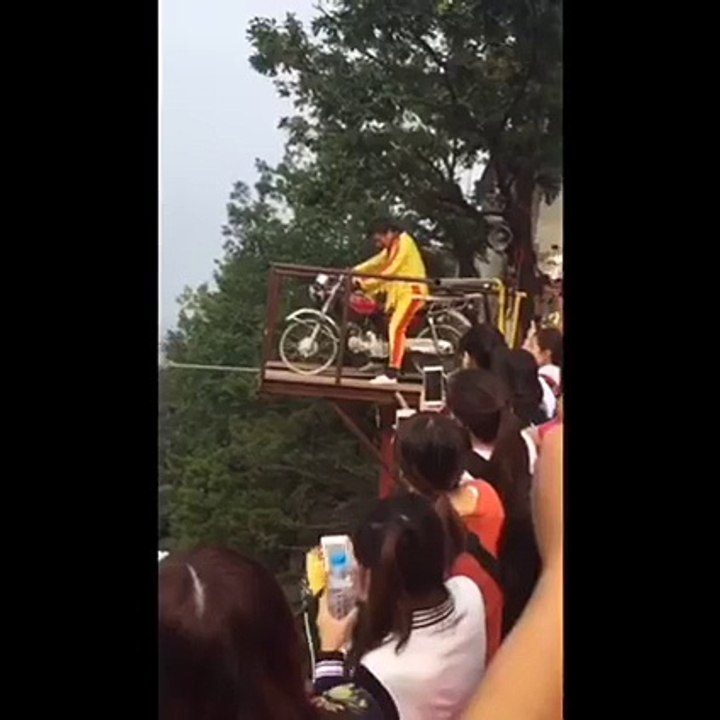 Conduire une moto sur un fil tendu au-dessus de la haute altitude