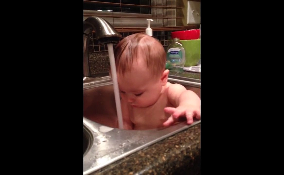 Bébé se fait surprendre par le jet d'eau