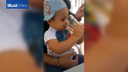 Deux Roumains font boire de la bière et fumer un enfant