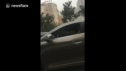 Woman addicted to karaoke sings with microphone while she's driving
