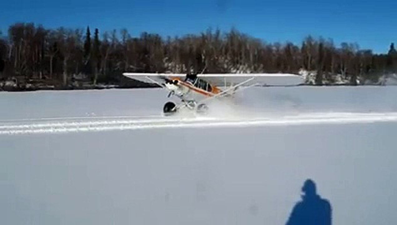 Un pilote fait des Drift en avion sur un lac ge...