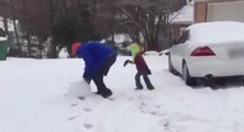 Un papa lance une boule de neige sur son enfant