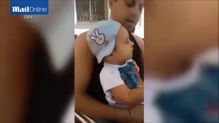 A little boy is made to smoke a cigarette and drink a glass of beer