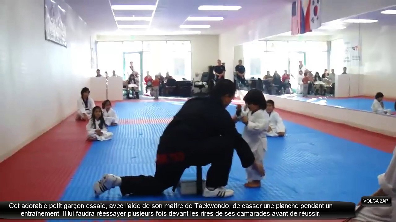 un petit garçon essai de casser une planche