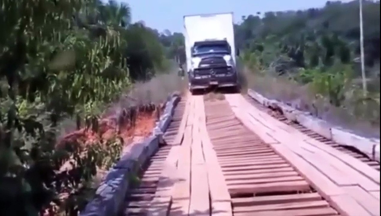 Camiòn pesado intenta cruzar un viejo puente de...