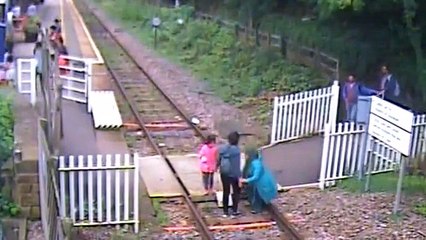 Leurs enfants s'assoient sur la voie ferrée pendant qu'ils font des photos