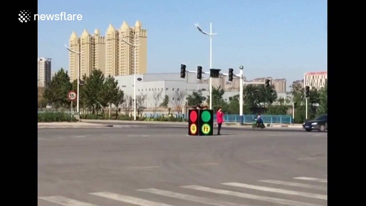 People dress up as traffic lights to direct traffic after real signals break