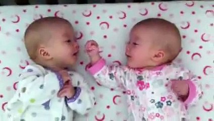 Identical twin girls engage in deep conversation with each other