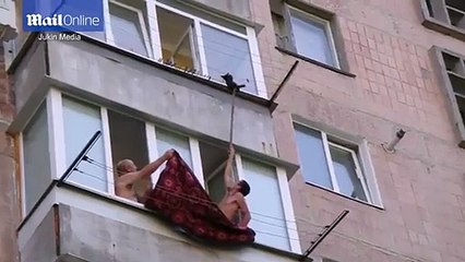 Dramatic moment men rescue kitten dangling from clothes line