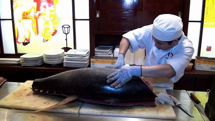 Sushi chef prepping a tuna
