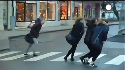 A STRONG WIND DRAGGING PEOPLE AWAY IN DAY TIME