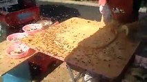 Chinese street food vendor isn't going to let a few bees stop him.