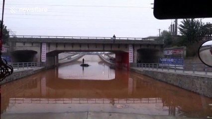 Firefighters in dinghy rescue man trapped in flood under bridge