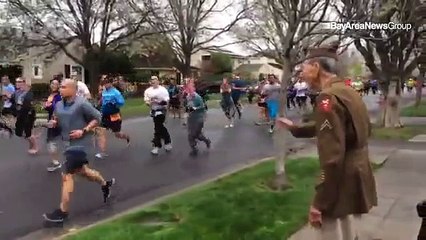Ces marathoniens remarquent un vétéran qui les observe. Découvrez maintenant ce qu'ils font tous pour lui rendre hommage