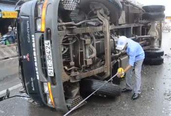 Đâm dải phân cách xe tải lật ngang đường trong mưa