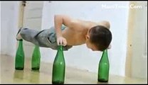 Small Boy Doing Push Ups on beer bottles