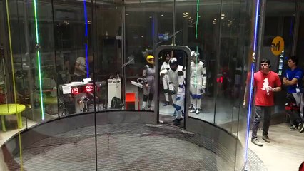 Des parachutistes s'entrainent à faire une formation dans une soufflerie