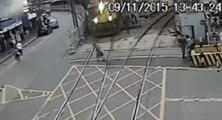 Un vieil homme traverse une voie ferrée juste devant un train