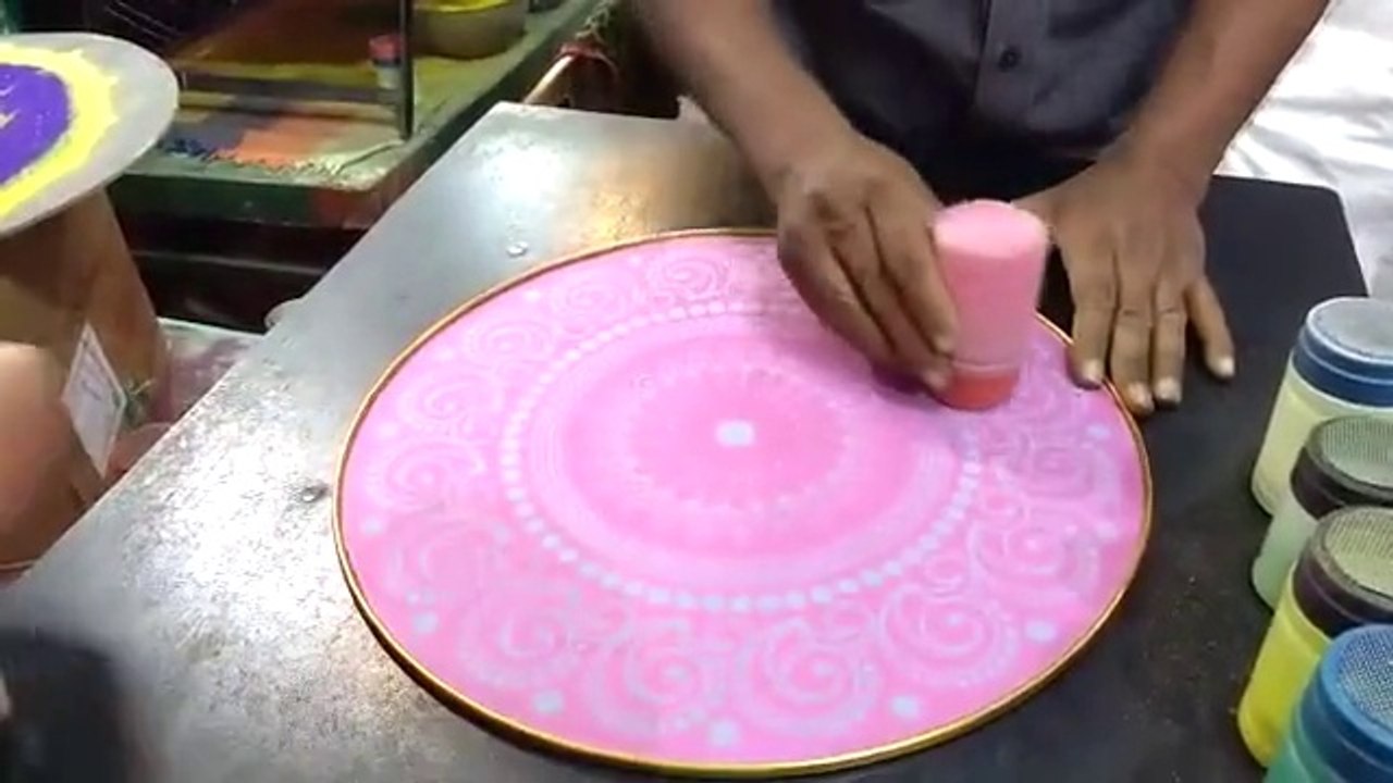 Un artiste de rue réalise une superbe peinture éphémère rangoli