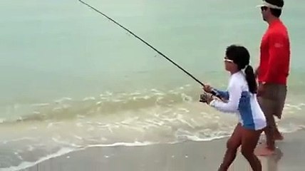 بنت صغيرة تصطاد سمكة كبيرة