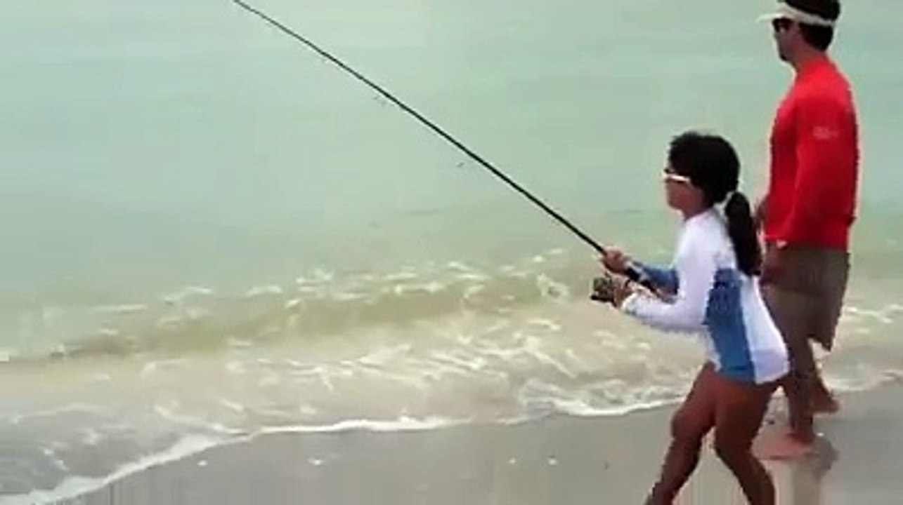 بنت صغيرة تصطاد سمكة كبيرة