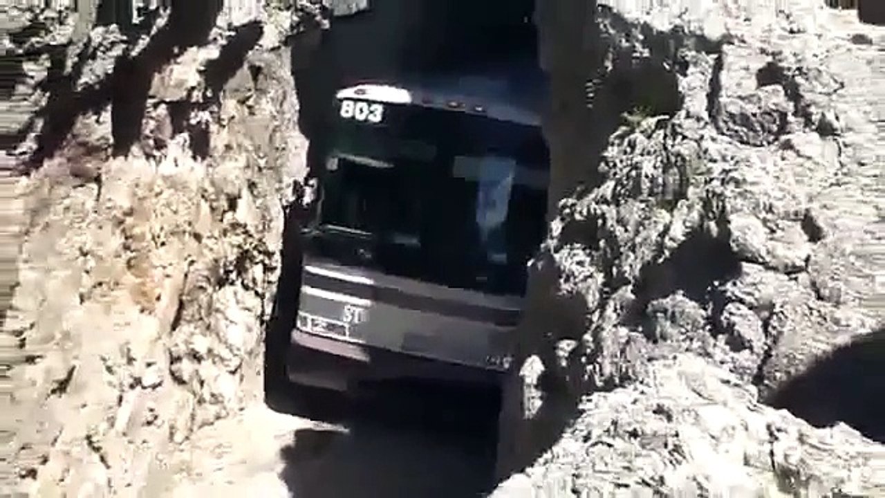 針に糸を通すように、狭い道を通るバス