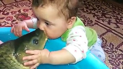Cute baby kissing to a fish