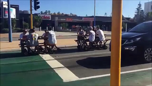 A few blokes driving motorized park benches while having a beer.