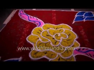 Indian woman makes floral rangoli using vibrant colours during Diwali